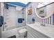 Charming bathroom with a tub and shower combination, and blue and white striped wall accents at 1281 Amberlea E Dr, Dunedin, FL 34698