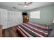 Bedroom features wood-look floors, a ceiling fan, and a double closet at 1281 Amberlea E Dr, Dunedin, FL 34698