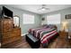 Bedroom features wood-look floors, a ceiling fan, and light green walls at 1281 Amberlea E Dr, Dunedin, FL 34698