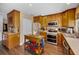 Traditional eat-in kitchen features stainless steel appliances and a rolling island cart at 1281 Amberlea E Dr, Dunedin, FL 34698