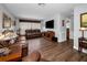 Spacious living room featuring hardwood floors, leather furniture, and a large flat-screen television at 1281 Amberlea E Dr, Dunedin, FL 34698