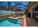 Inviting screened-in pool area with brick-paved patio and ample space for outdoor entertaining at 1281 Amberlea E Dr, Dunedin, FL 34698