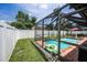Enclosed pool area with an inflatable alligator and brick surround, perfect for relaxation and fun at 1281 Amberlea E Dr, Dunedin, FL 34698