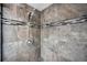 Shower features stone-look tile and black and white accent tiles at 1281 Amberlea E Dr, Dunedin, FL 34698