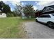 Backyard of a home with a pool and screened in patio with a white SUV parked nearby at 13400 10Th St, Dade City, FL 33525