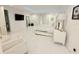 This spacious bedroom features all-white décor and a TV, creating a serene retreat at 13400 10Th St, Dade City, FL 33525