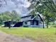 Charming two-story home features a well-manicured lawn, mature trees, and a side entry covered parking at 13400 10Th St, Dade City, FL 33525