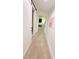 Well-lit hallway with beige carpet leading to a room with a bed at 13400 10Th St, Dade City, FL 33525