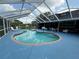 Screened-in kidney-shaped pool area with ample seating, surrounded by well-maintained patio at 13400 10Th St, Dade City, FL 33525