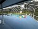 Screened pool with lounge chairs and colorful pool floats surrounded by tropical landscape at 13400 10Th St, Dade City, FL 33525