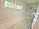 Stylish marble shower with a window, bench, and contemporary showerhead fixtures at 13400 10Th St, Dade City, FL 33525