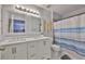 Bathroom featuring a double sink vanity, modern mirrors, and a blue and white shower curtain at 13750 Fareham Rd, Odessa, FL 33556