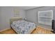 Bedroom with light blue walls, wood flooring, a decorative painting, and a comfortable bed at 13750 Fareham Rd, Odessa, FL 33556