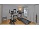 Exercise room with treadmill, elliptical machine, hardwood floors and natural light at 13750 Fareham Rd, Odessa, FL 33556