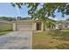 Charming single-story home with a well-maintained lawn, an attached garage, and mature landscaping at 13750 Fareham Rd, Odessa, FL 33556