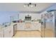 Bright kitchen with white cabinets, stainless steel appliances, a corner sink, and tile flooring at 13750 Fareham Rd, Odessa, FL 33556