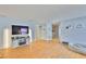 Bright living room featuring wood floors, a modern TV and a dog bed at 13750 Fareham Rd, Odessa, FL 33556