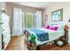 Charming bedroom featuring hardwood floors, a comfortable bed, and bright natural light from the large windows at 1423 Dr Martin Luther King Jr N St, St Petersburg, FL 33704