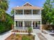 Charming two-story home features a welcoming front porch with decorative landscaping at 1423 Dr Martin Luther King Jr N St, St Petersburg, FL 33704