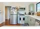 The kitchen features stainless steel appliances, light green cabinets, and hardwood floors at 1423 Dr Martin Luther King Jr N St, St Petersburg, FL 33704