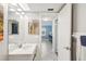 Bright bathroom with a white vanity, ample lighting, and tile flooring leading to another room at 14401 Gulf Blvd # 106, Madeira Beach, FL 33708