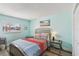 Comfortable bedroom featuring a window, queen bed with beach themed artwork, and laminate floors at 14401 Gulf Blvd # 106, Madeira Beach, FL 33708