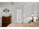 Bedroom showcasing the neutral decor, a glimpse into an adjacent bathroom, and classic wooden furniture at 1633 Bentwood Dr, Sun City Center, FL 33573