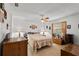 Cozy bedroom features a ceiling fan, natural light from the window, and classic wooden furniture, creating a relaxing space at 1633 Bentwood Dr, Sun City Center, FL 33573