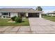 Well-maintained single-story home with a carport and manicured front lawn and mature landscaping at 1633 Bentwood Dr, Sun City Center, FL 33573