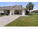 Charming home with a well-kept lawn, a golf cart, and a welcoming driveway at 1633 Bentwood Dr, Sun City Center, FL 33573