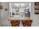 Bright kitchen features white cabinets, granite countertops, stainless steel appliances, and a cozy breakfast bar with rattan chairs at 1633 Bentwood Dr, Sun City Center, FL 33573
