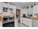 Well-equipped kitchen featuring an electric range, ample counter space, stainless steel sink, and convenient access to a laundry room at 1633 Bentwood Dr, Sun City Center, FL 33573