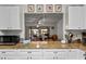 Stylish kitchen boasting white cabinets, granite countertops, stainless microwave, and an open view into an adjacent living space at 1633 Bentwood Dr, Sun City Center, FL 33573