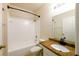 Bright bathroom with a vanity featuring a granite countertop, a soaking tub, and tile floors at 16431 Enclave Village Dr # 16431, Tampa, FL 33647