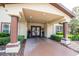 Community entrance featuring mature landscaping, a covered entry, and convenient package receiving at 16431 Enclave Village Dr # 16431, Tampa, FL 33647
