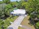 Aerial view of home with long driveway, backyard pool, updated roof and lush landscaping at 1817 West Dr, Clearwater, FL 33755