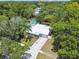 Aerial view of a home with a white roof, surrounded by lush greenery and a private pool area at 1817 West Dr, Clearwater, FL 33755