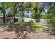 Wide backyard featuring a well-maintained lawn, white fence, mature trees, and rear view of the home at 1817 West Dr, Clearwater, FL 33755