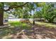 Spacious backyard featuring lush landscaping, privacy fence, and mature trees providing ample shade at 1817 West Dr, Clearwater, FL 33755