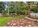 A well-maintained backyard with lush landscaping, grass, stone accents, and a white fence at 1817 West Dr, Clearwater, FL 33755