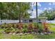 Landscaped backyard featuring garden beds with mature plants, a white fence, and the back of the house at 1817 West Dr, Clearwater, FL 33755