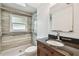 Remodeled bathroom featuring a tile shower, grab bars, a dark vanity, and an above-counter sink at 1817 West Dr, Clearwater, FL 33755