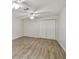 Bedroom with wood-look tile flooring, double closet doors, a ceiling fan, and neutral paint at 1817 West Dr, Clearwater, FL 33755