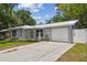 Inviting single-story home featuring a well-manicured lawn and attached garage at 1817 West Dr, Clearwater, FL 33755