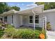 Inviting front entrance of gray home, featuring well-maintained landscaping and a Vivint SmartHome security sign at 1817 West Dr, Clearwater, FL 33755