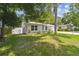 Charming home with lush green lawn, rock borders, flowering plants and a newer privacy fence at 1817 West Dr, Clearwater, FL 33755