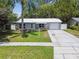 Charming single-story home with a well-manicured front yard and metal roof at 1817 West Dr, Clearwater, FL 33755