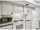 A kitchen featuring a microwave, stove, refrigerator, and wooden cabinets at 1817 West Dr, Clearwater, FL 33755