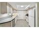 Bright kitchen featuring light-colored cabinets, stone countertops, and appliances, under a skylight at 1817 West Dr, Clearwater, FL 33755