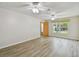 Bright living room with wood-look flooring, dual ceiling fans, and plenty of natural light at 1817 West Dr, Clearwater, FL 33755